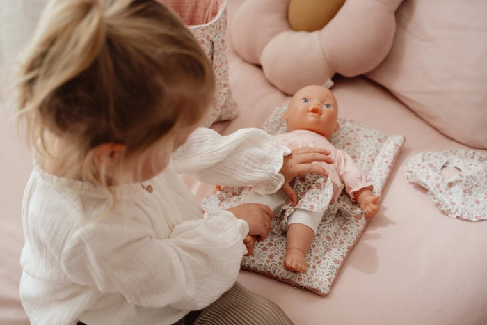 Kind spielt mit Puppenwickeltasche Soft Flowers und Puppenzubehör